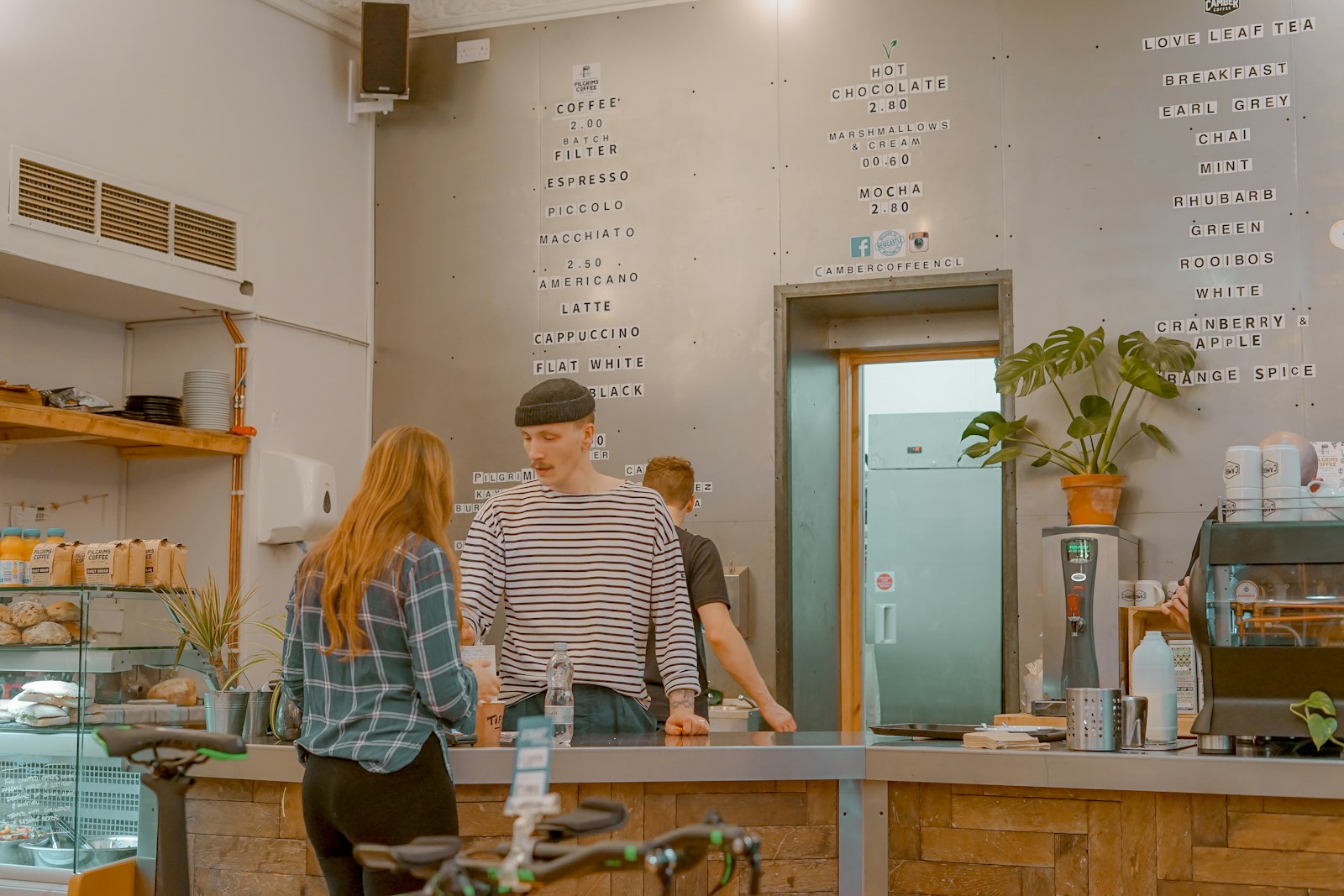 The sunlit cafe interior with seating and plants